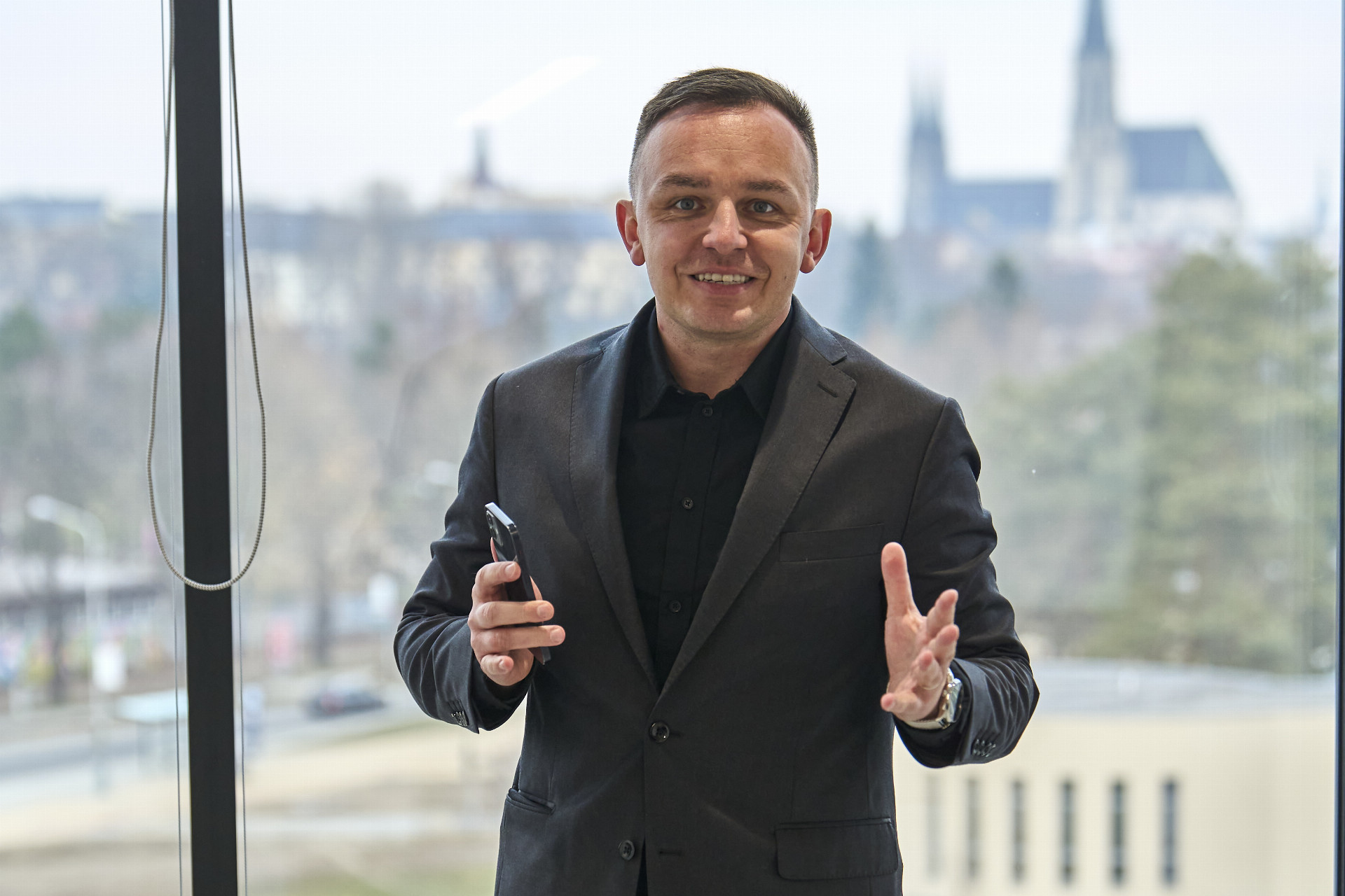 Person discussing AI and personal data in 2024, holding a smartphone, with cityscape background.