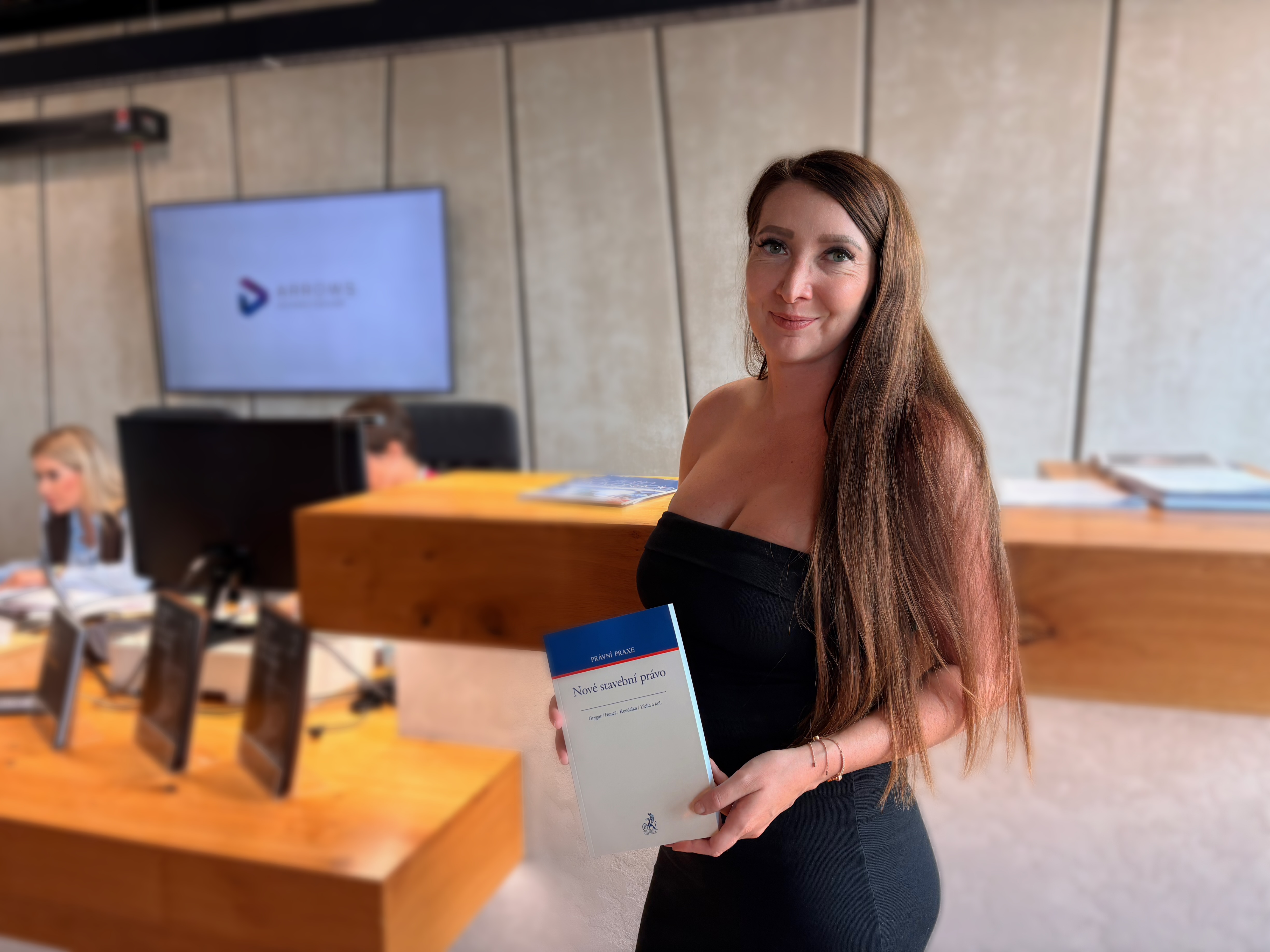A woman at ARROWS holds a book on the new Building Act.