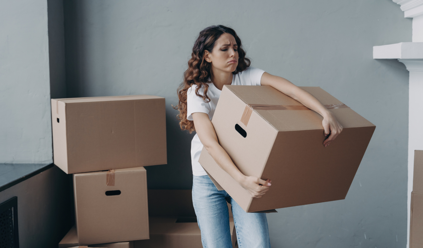Woman carrying moving boxes, illustrating tenant eviction without court order using a notarial deed.