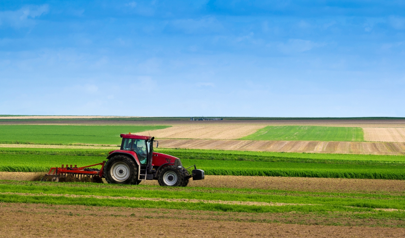 Tractor working on agricultural land, related to foreign purchase restrictions and procedures.